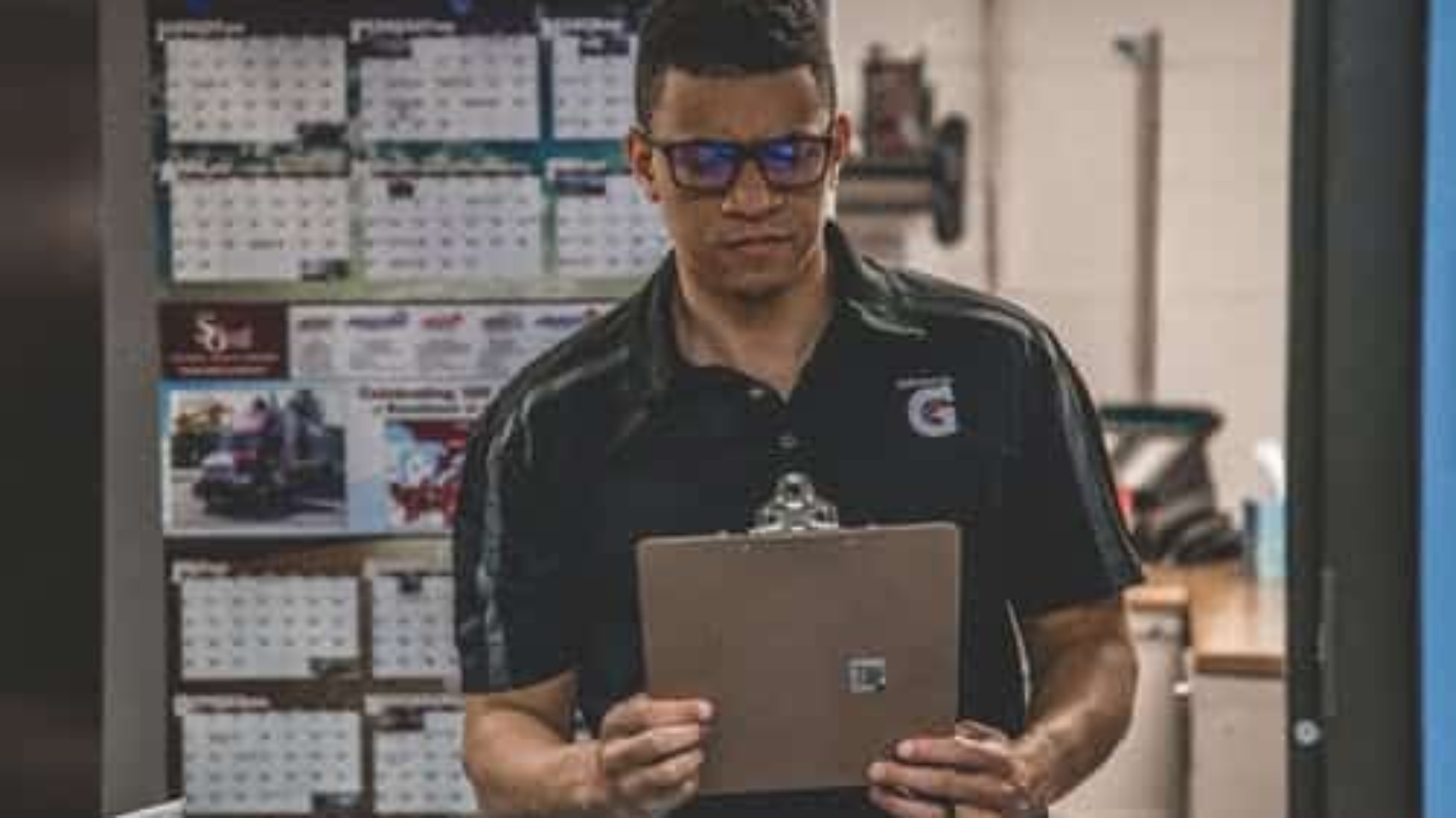 warehouse worker holding and looking at clipboard