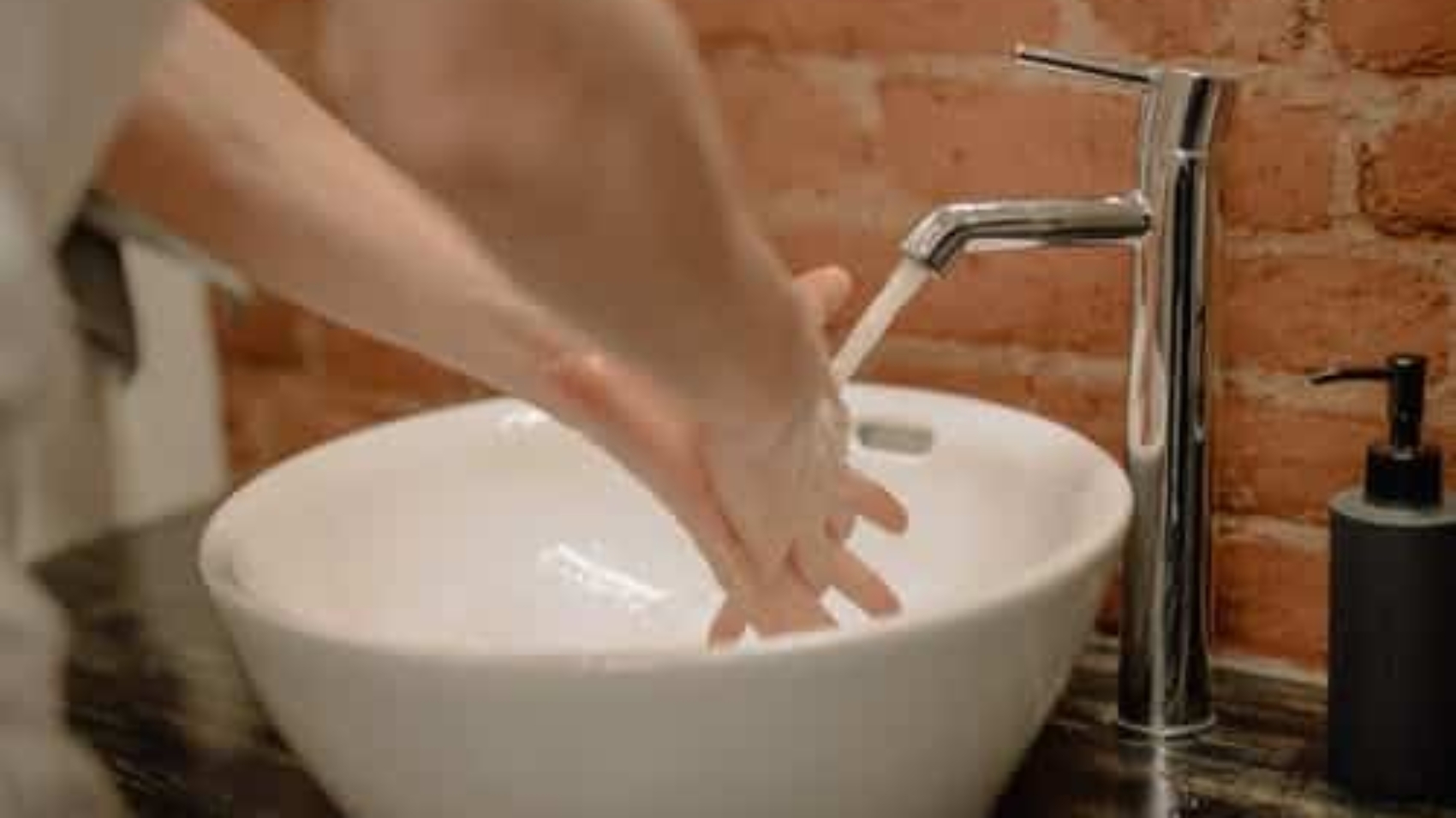 person washing their hands at sink