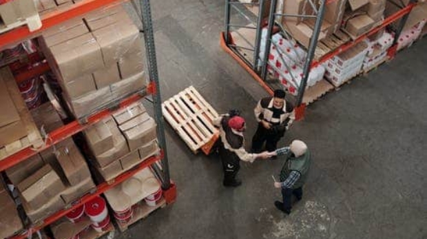 two warehouse workers shaking hands
