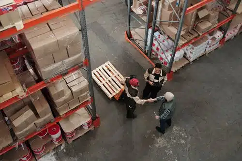 two warehouse workers shaking hands