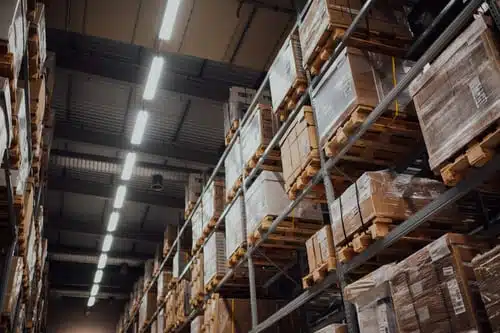 boxes on racks beneath florescent lights