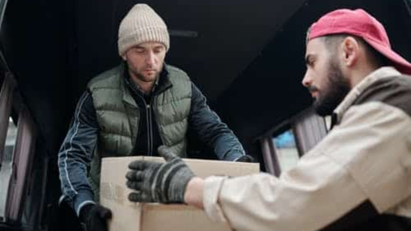 one worker passing a box to another