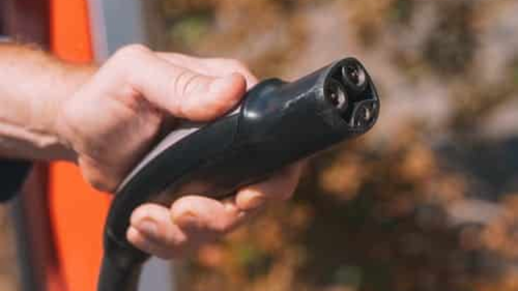 person holding electric car charger