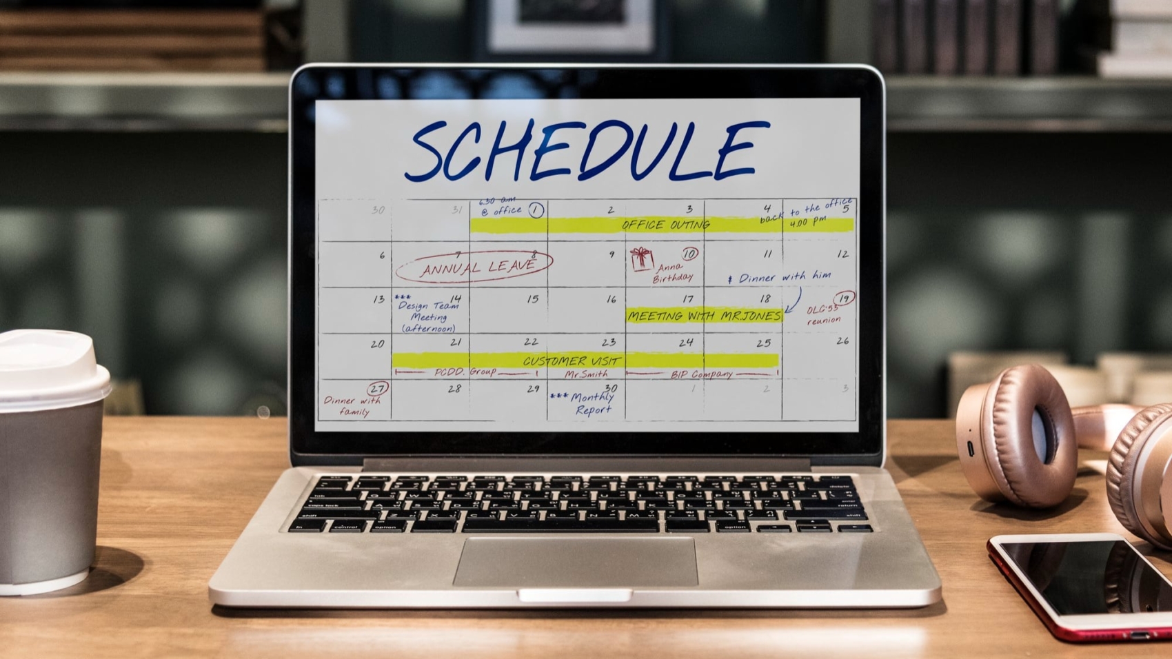 laptop on a table with a monthly schedule on the screen