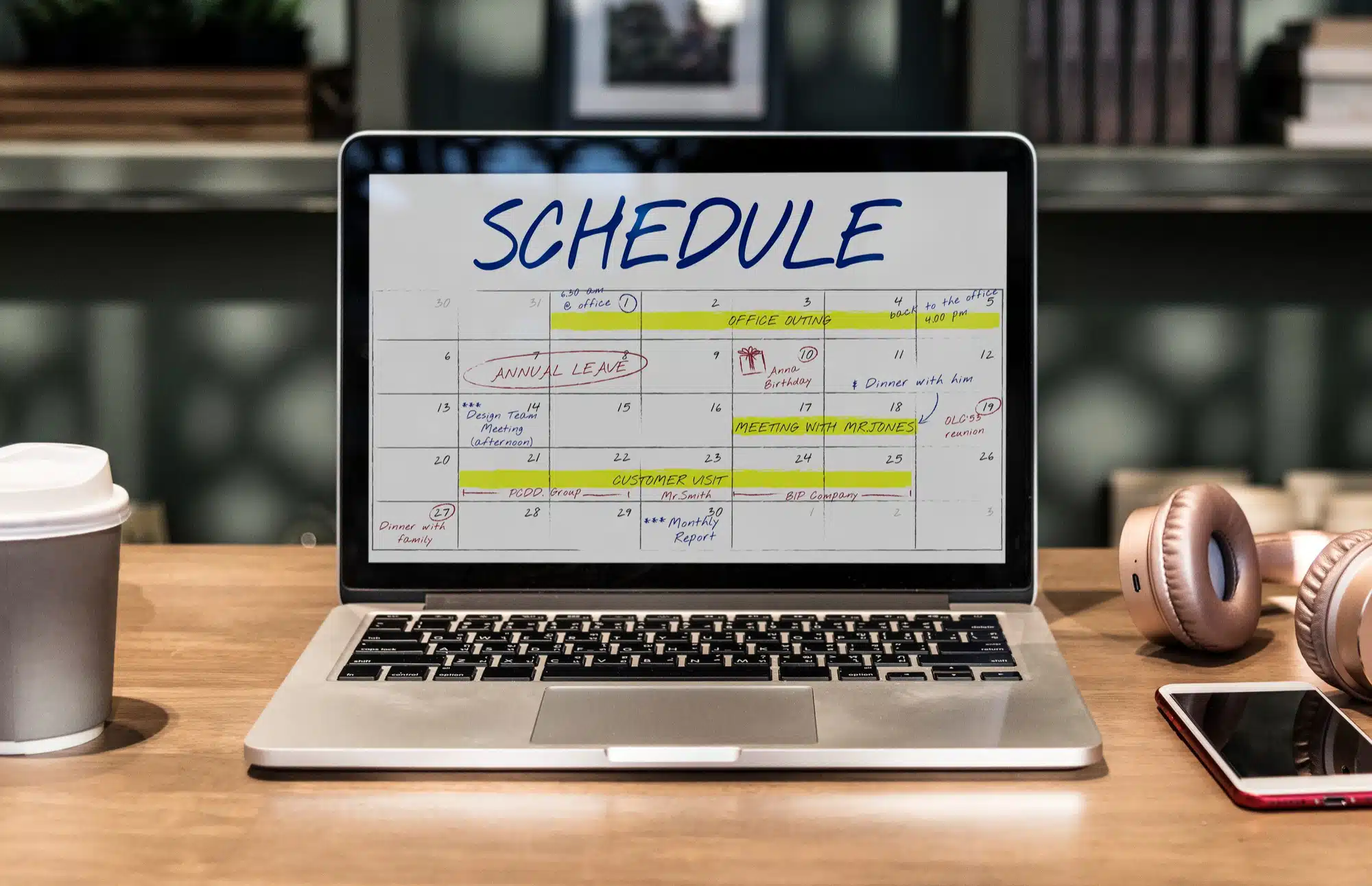 laptop on a table with a monthly schedule on the screen