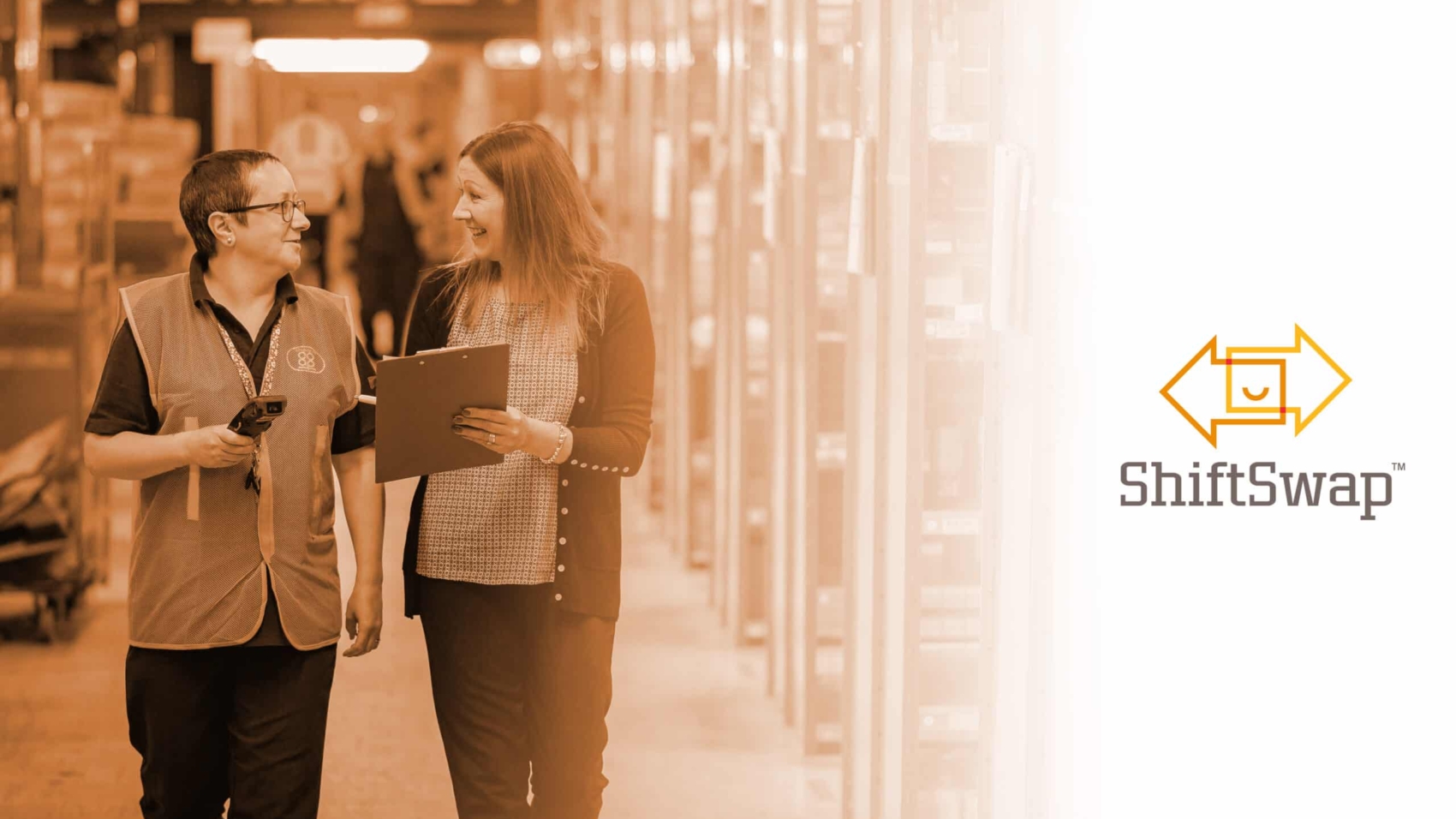 Two women walking in a warehouse, one with a clipboard. Featured image for Top 5 Benefits of Flexibility for Your Hourly Workforce with the ShiftSwap™ logo on the right