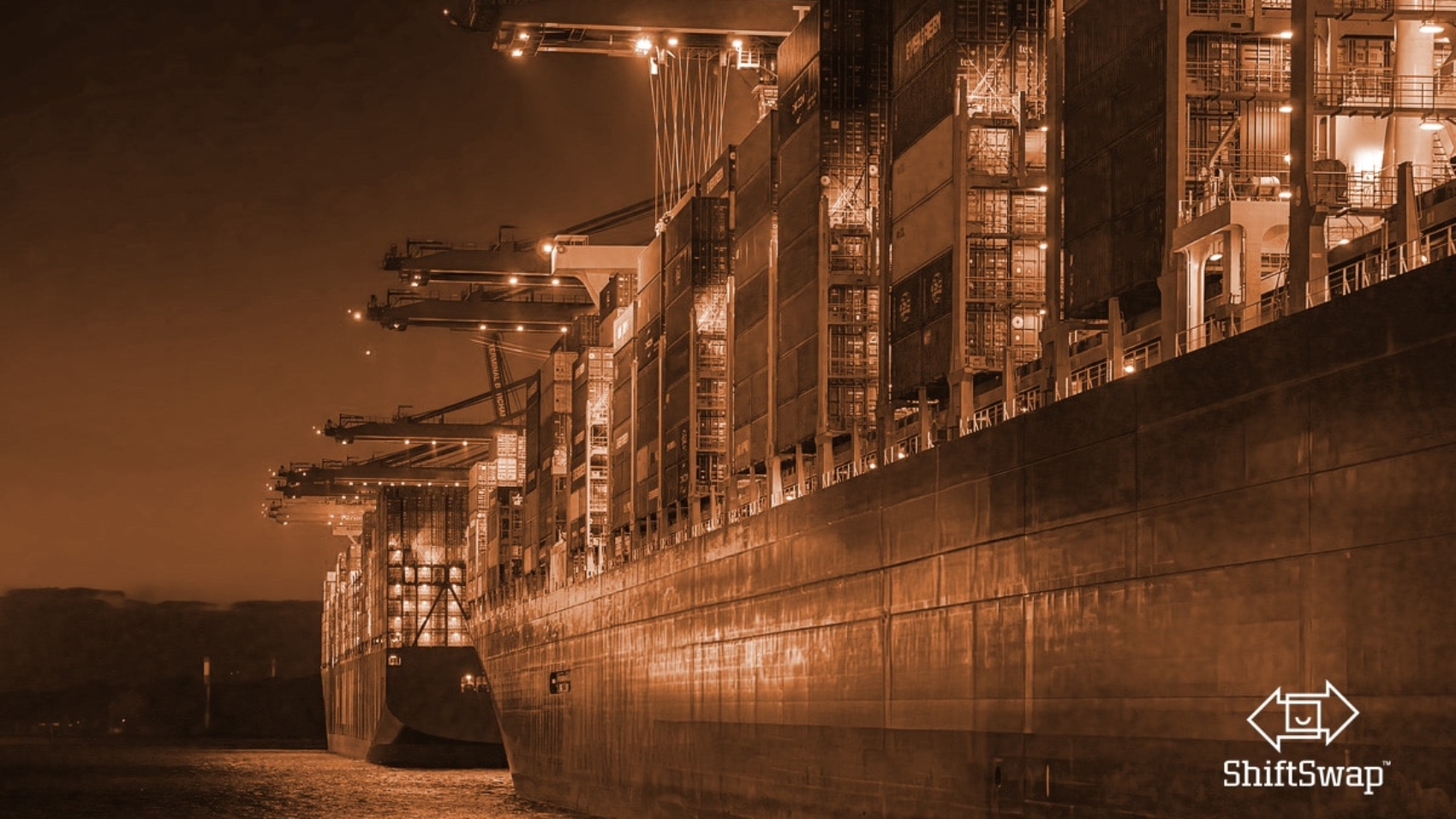 Shipping containers at the dock with an orange hue over the image. 2025 tariffs will be making an impact on imports.