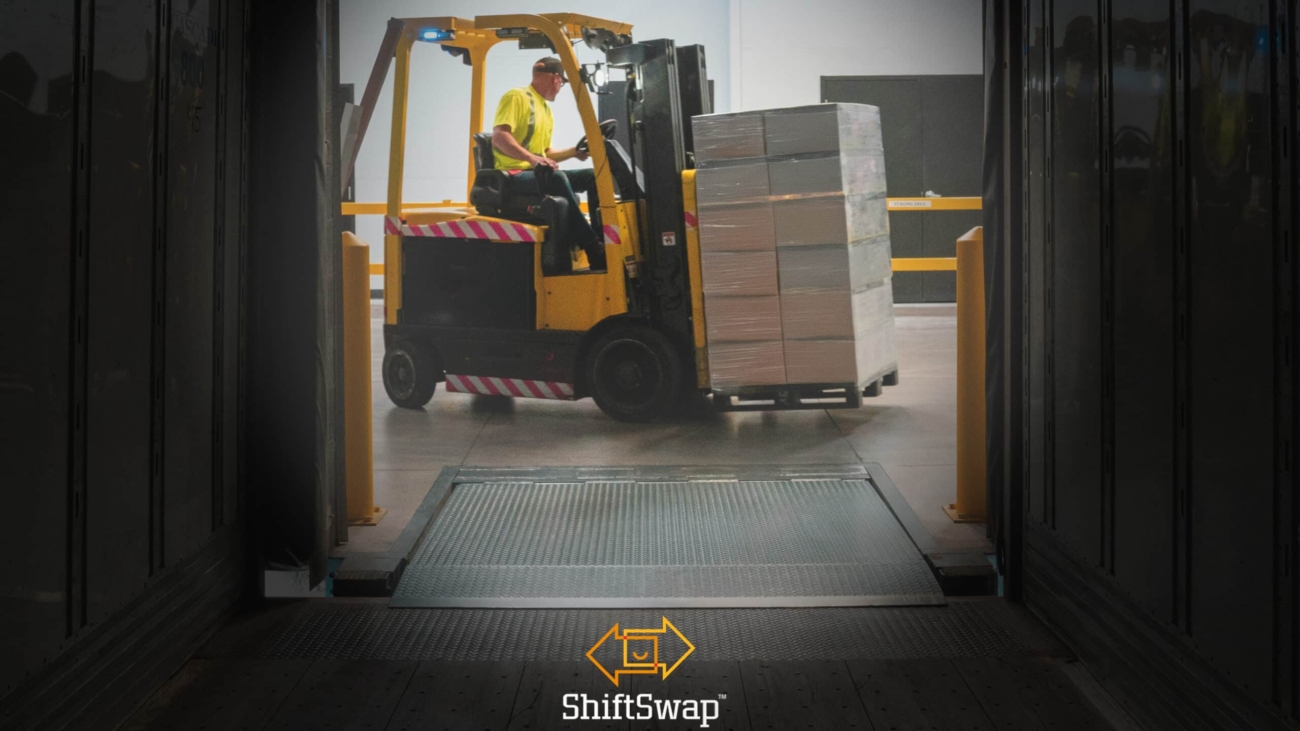 A warehouse worker is unloading boxes on a machine from a truck. Used for the Mastering Volatility in Warehousing Operations Article