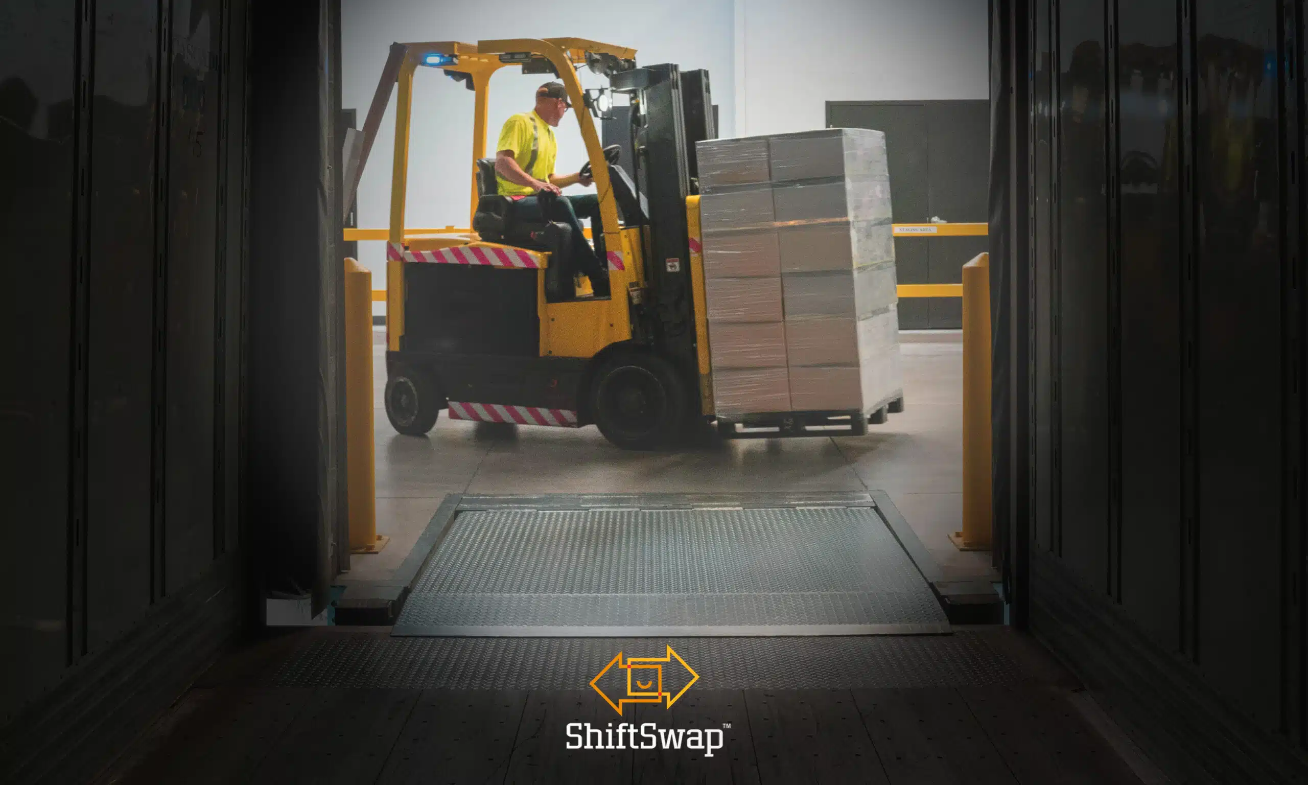 A warehouse worker is unloading boxes on a machine from a truck. Used for the Mastering Volatility in Warehousing Operations Article