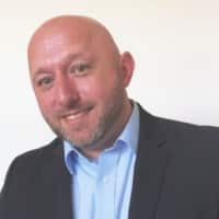 male in a suit smiling