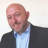 male in a suit smiling