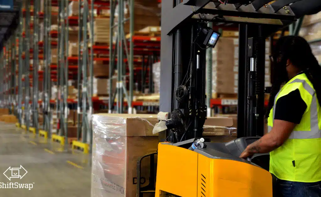 warehouse worker operating a forklift with inventory