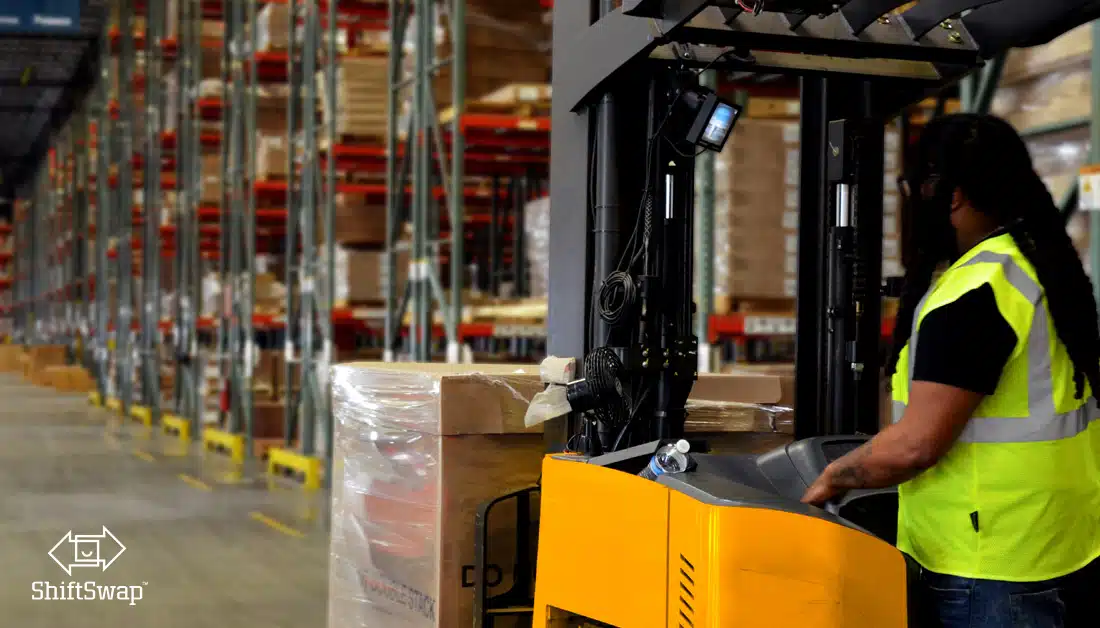 warehouse worker operating a forklift with inventory