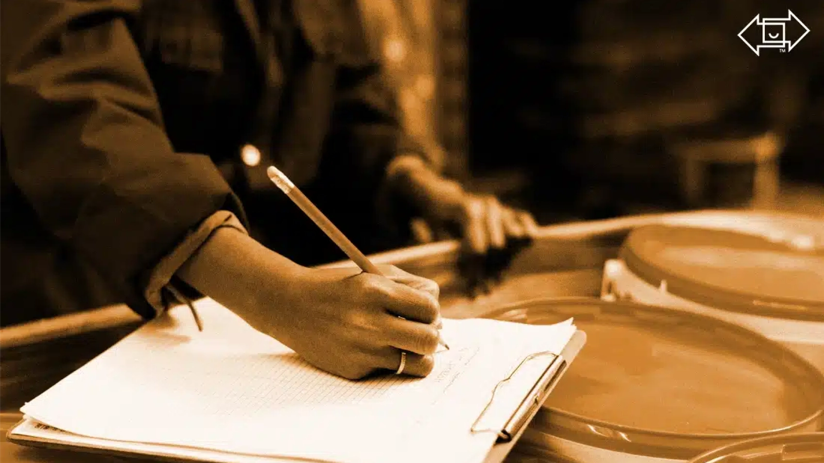 warehouse working writing on a clipboard on top of supply