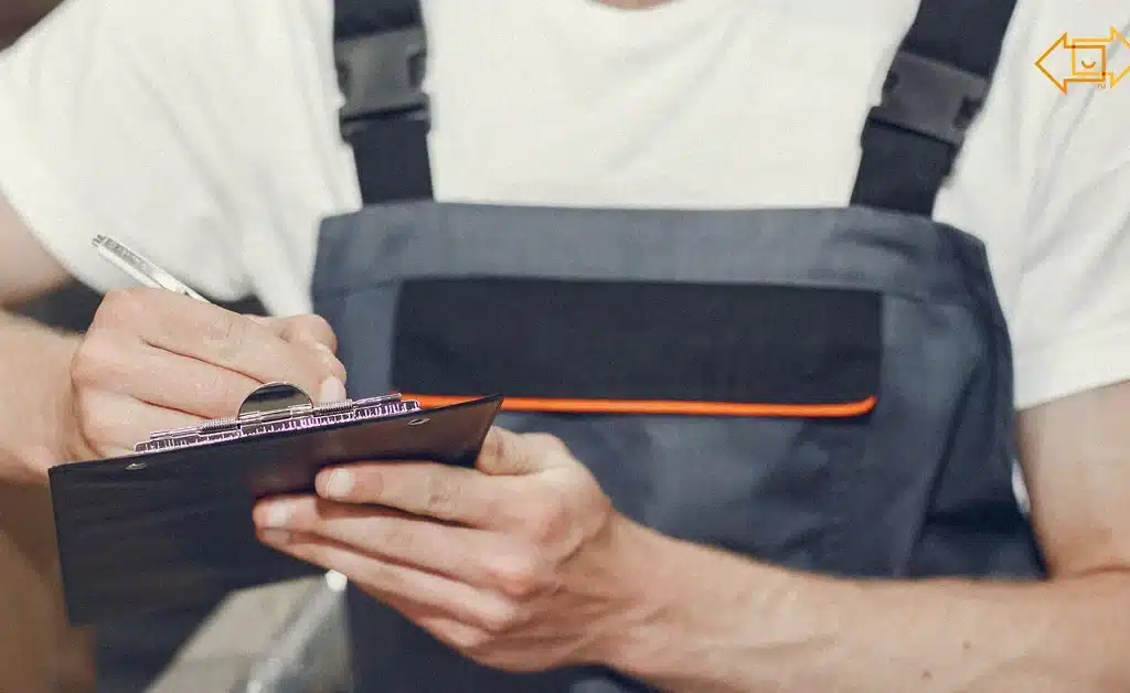 male worker writing something down on a clipboard