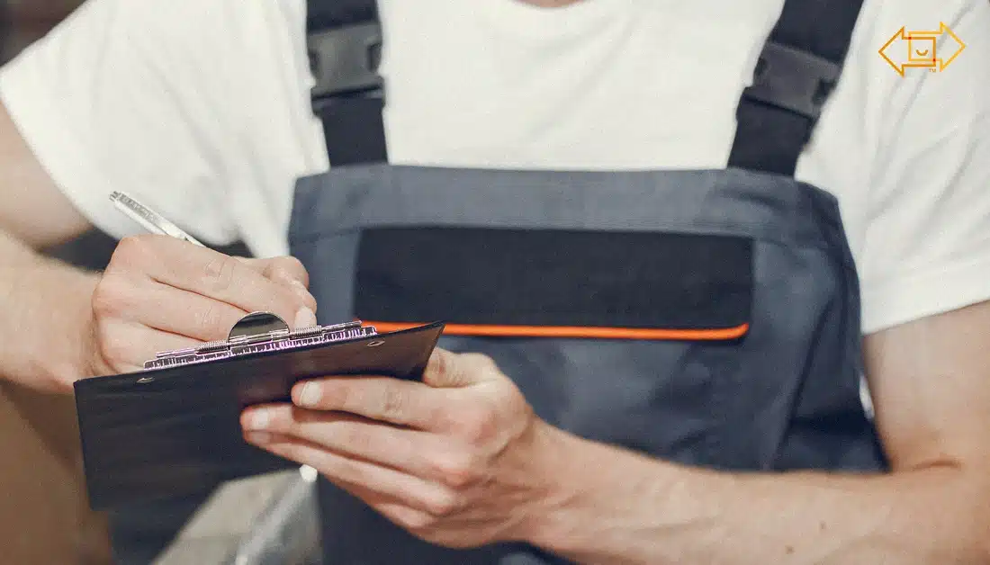 male worker writing something down on a clipboard