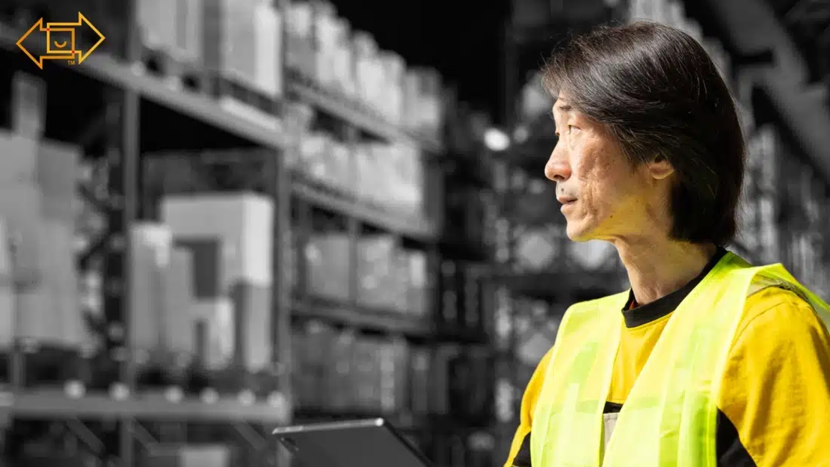 male warehouse worker looking at the site with a tablet in hand