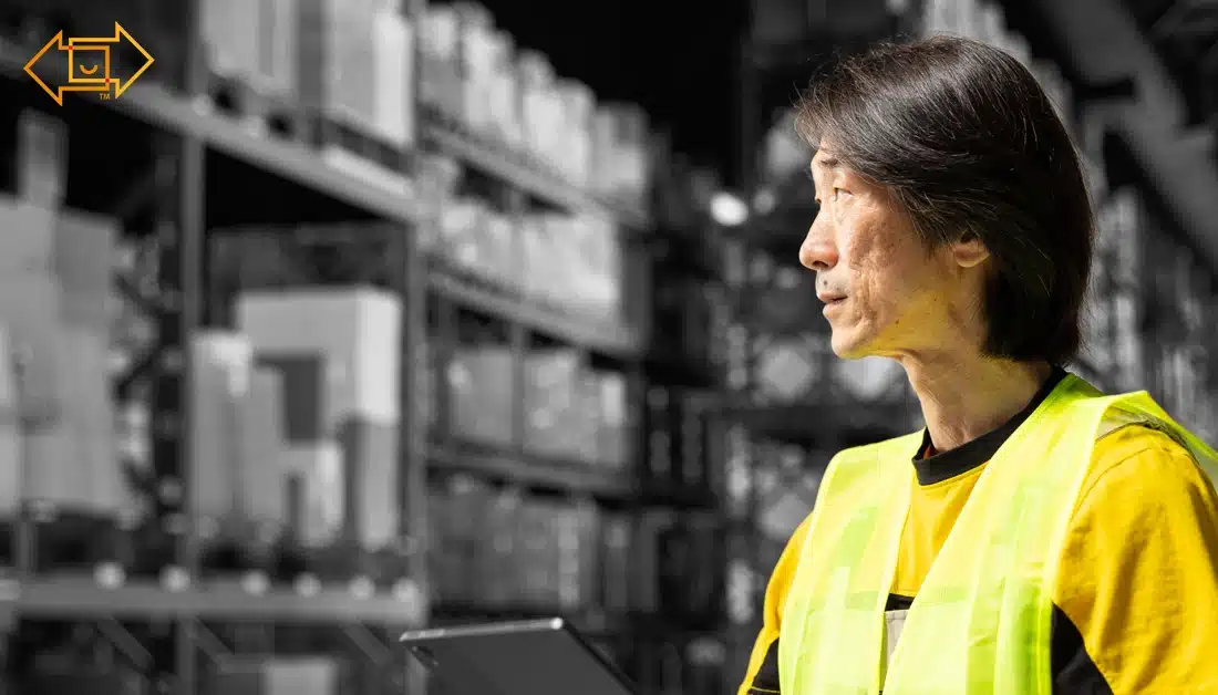male warehouse worker looking at the site with a tablet in hand