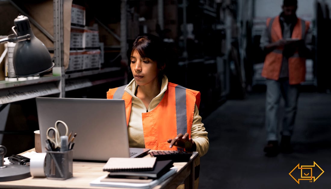 warehouse worker with a calculator and laptop
