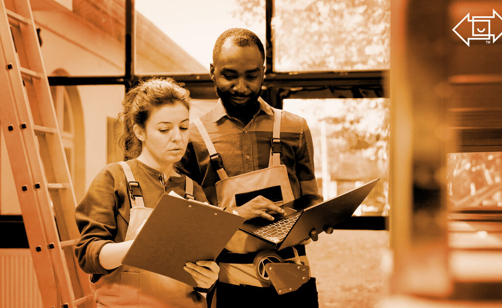 two warehouse workers with a clipboard and laptop looking over materials for effective shift management