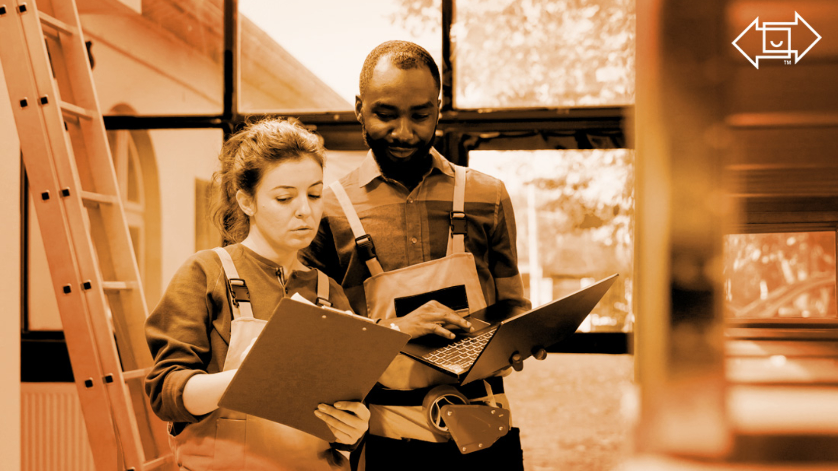 two warehouse workers with a clipboard and laptop looking over materials for effective shift management