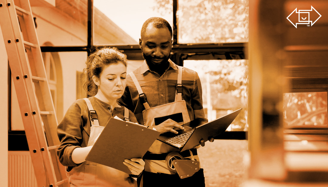 two warehouse workers with a clipboard and laptop looking over materials for effective shift management