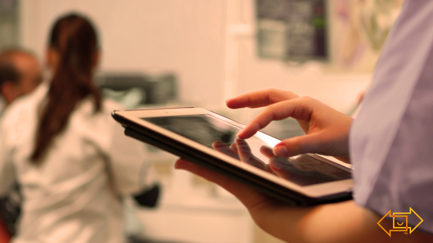healthcare employee on an ipad while nurse is with a patient