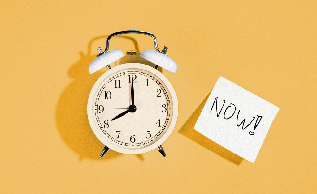 image of an analog clock with a sticky note stating "now." Reducing absenteeism in the workforce