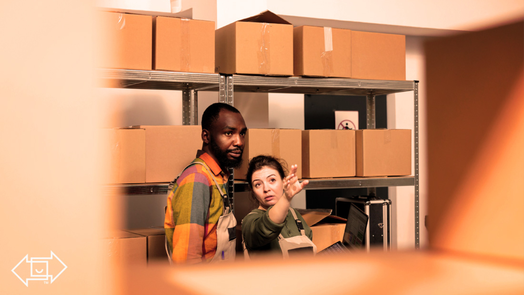 warehouse employees surrounded by boxes pointing at the warehouse