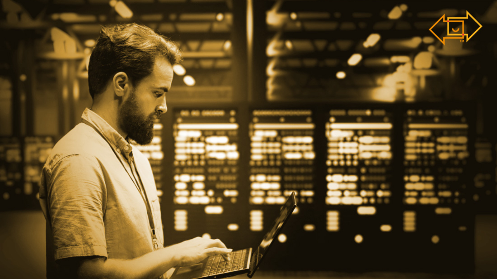 data center warehouse interior with an employee standing working on his laptop