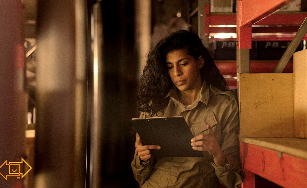 warehouse worker looking at clipboard looking engaged to her task