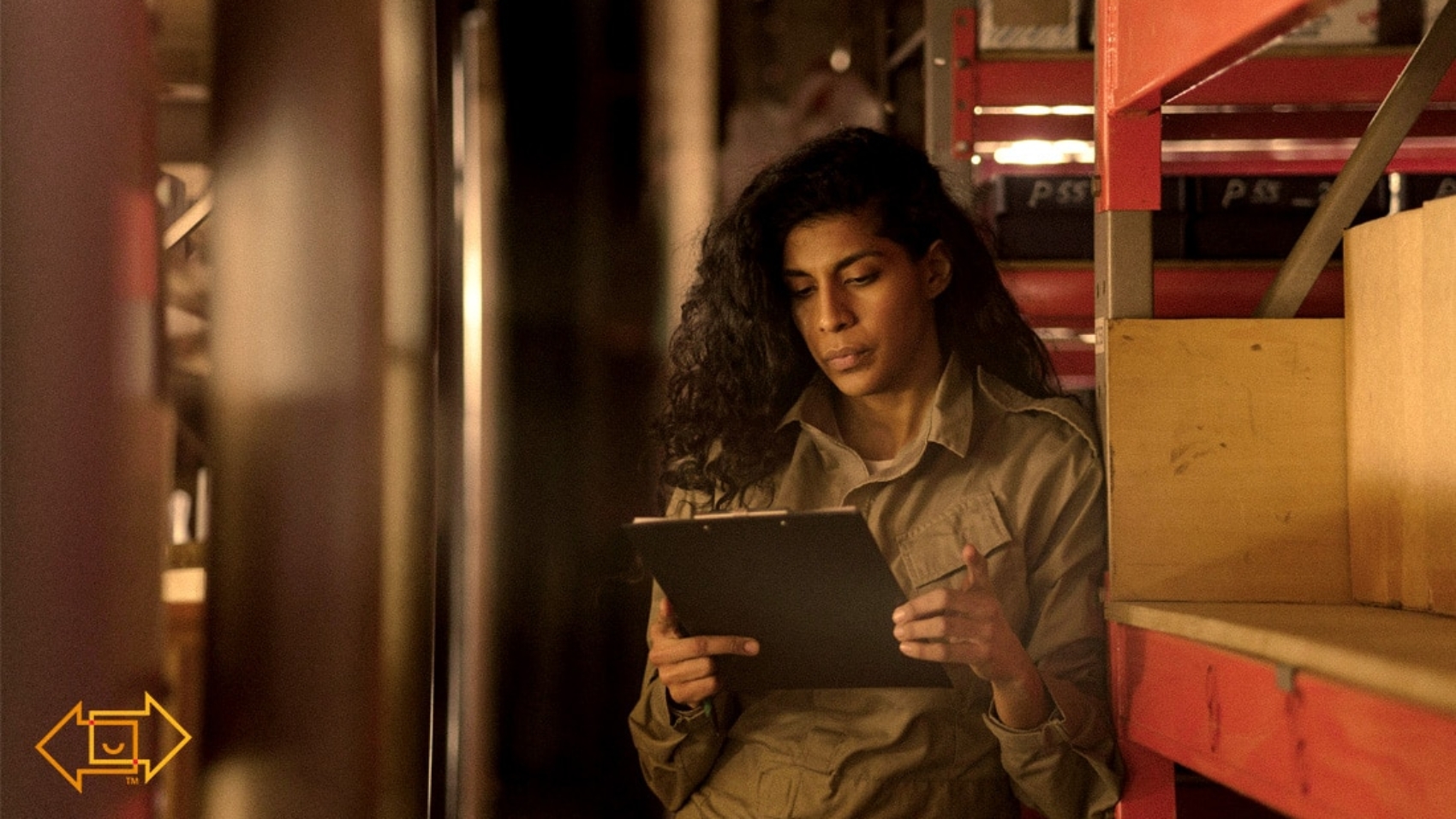 warehouse worker looking at clipboard looking engaged to her task