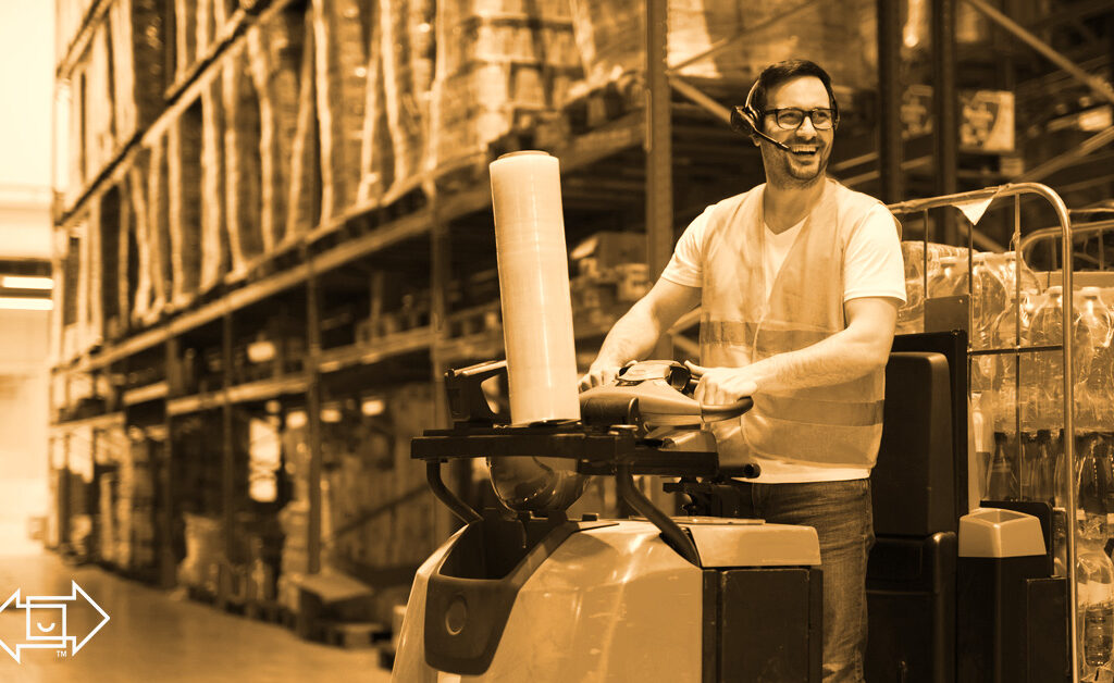 warehouse employee on a machine smiling