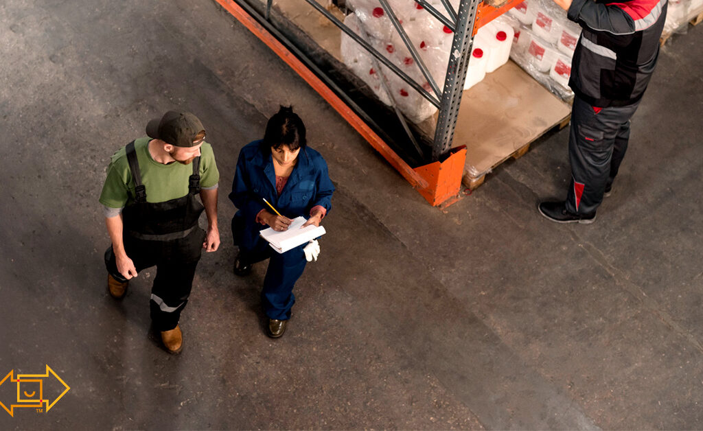 warehouse employees discussing and walking together while one holds a clipboard