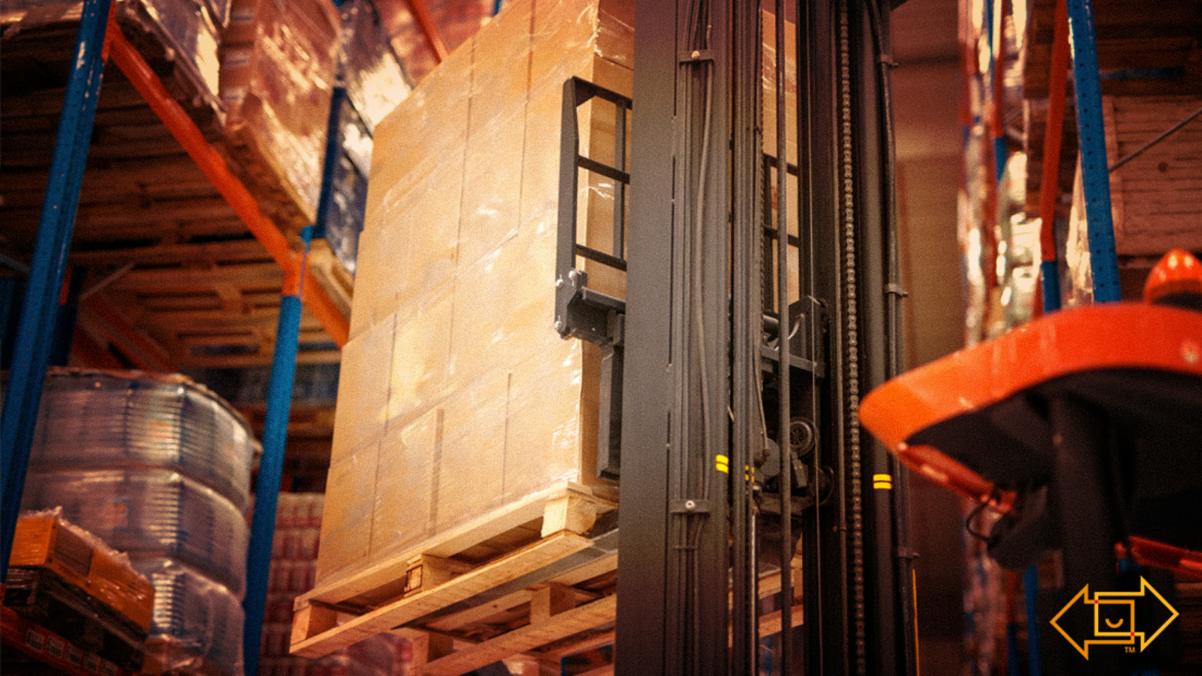 industrial forklift machine lifting palette of cardboard boxes and placing them on shelves in a warehouse